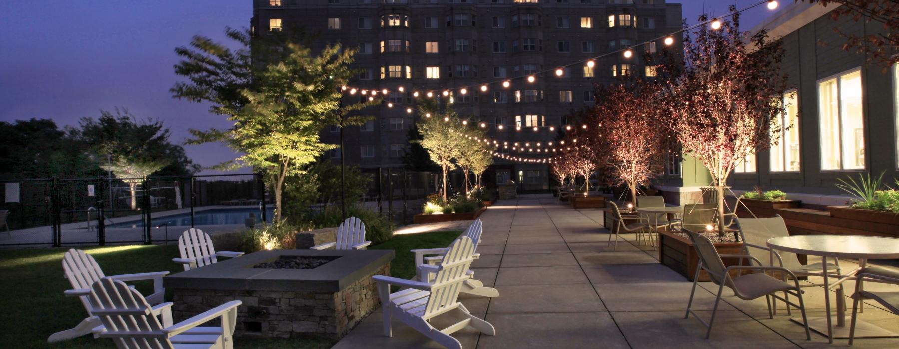 a building with a pool and chairs outside