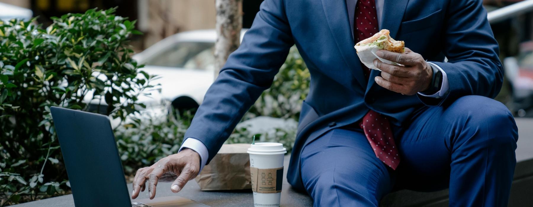 a person sitting at a table with a laptop and a cup of coffee